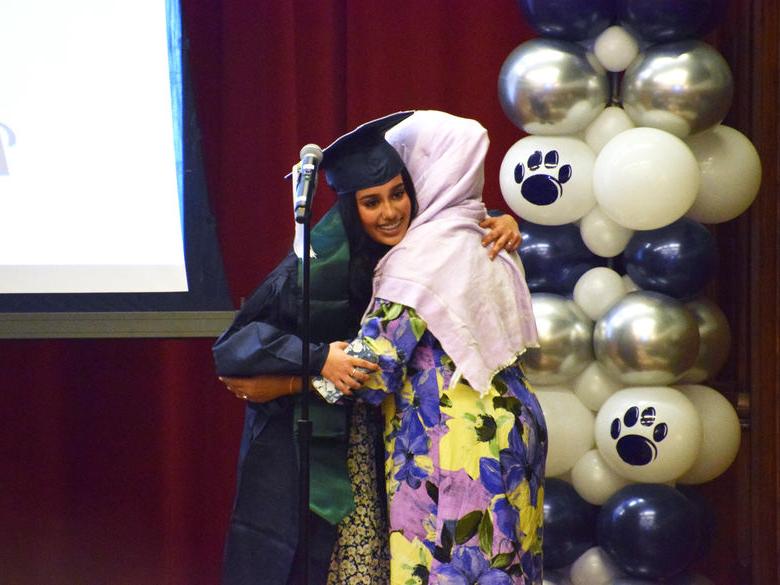 两个学生在文化毕业典礼上拥抱 